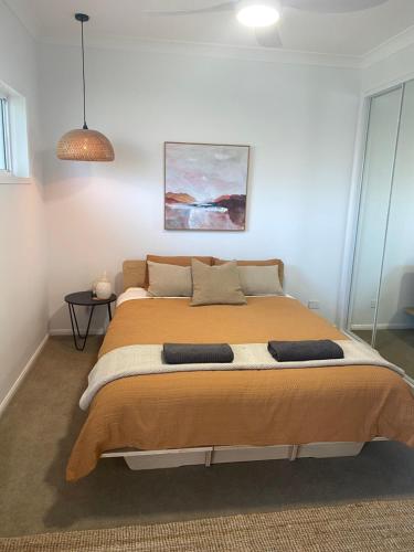 堤維德岬的住宿－Tweed River Retreat，一间卧室配有一张大床和两个枕头
