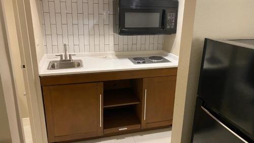 uma pequena cozinha com um lavatório e um micro-ondas em Baymont Inn by Wyndham Odessa University Area em Odessa