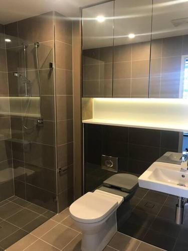 uma casa de banho com um WC, um chuveiro e um lavatório. em Beautiful one bedroom apartment in St Leonards-ATC62209 em Sydney