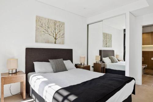 um quarto com 2 camas e 2 janelas em Beautiful one bedroom apartment in St Leonards-ATC62209 em Sydney