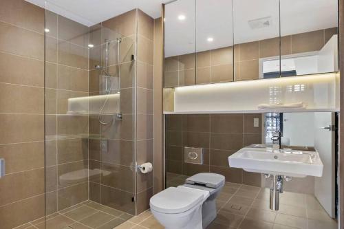 uma casa de banho com um WC, um lavatório e um chuveiro em Beautiful one bedroom apartment in St Leonards-ATC62209 em Sydney