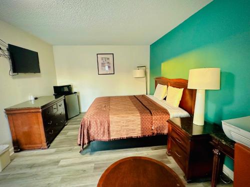 Habitación de hotel con cama y escritorio en King's Inn Motel en Kingsburg