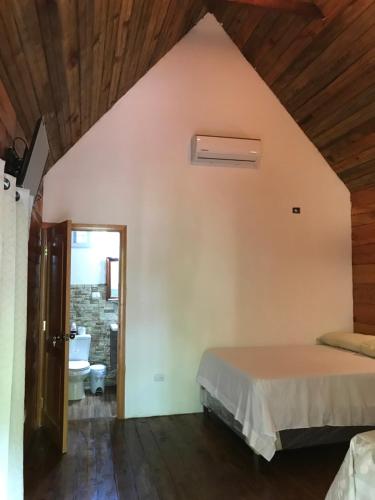 a bedroom with a bed and a bathroom with a sink at Hospedaje En El Lago… 