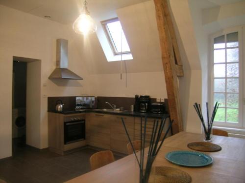 une cuisine avec une table, un évier et une fenêtre dans l'établissement Spacieux gîte près d'un château avec parc, 4 chambres, 2 sdb, Wifi, et animaux acceptés. - FR-1-489-215, à Trévol
