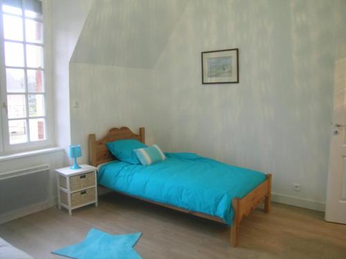 1 dormitorio con cama con sábanas azules y ventana en Appartement Trévol, 5 pièces, 8 personnes - FR-1-489-215, en Trévol