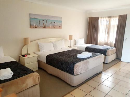 a hotel room with two beds in a room at Rockhampton Palms Motor Inn in Rockhampton