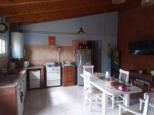 a kitchen with a white table and white appliances at Departamento Trelew in Trelew