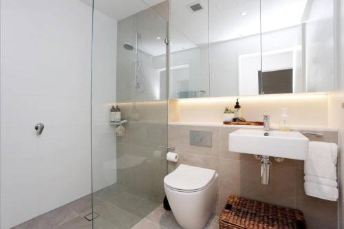 a bathroom with a toilet and a sink and a shower at Large One Bedroom with Study-ALB09203 in Sydney