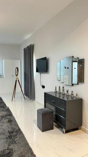 Habitación con tocador, TV y espejo. en Bidiyah arco hotel, en Badīyah