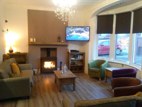 a living room with a fireplace and a tv at The Beaucliffe Hotel in Blackpool