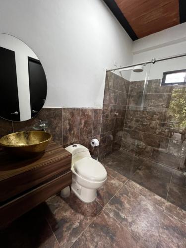 ein Badezimmer mit Toilette, Waschbecken und Dusche in der Unterkunft EL MILAGRO FINCA VACACIONAL in San Rafael