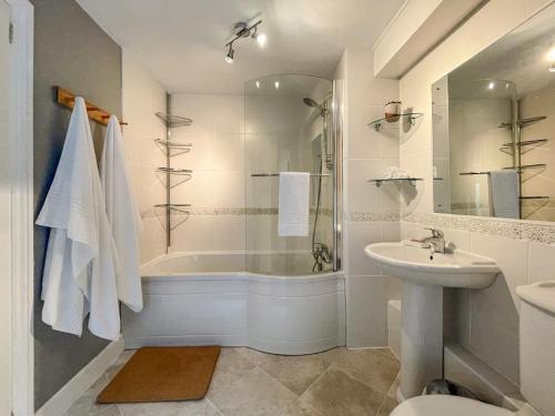 a bathroom with a tub and a sink and a shower at Glasfryn in Dolgellau