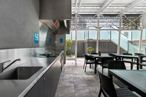 a kitchen with tables and chairs and a counter at Surfers Century Oceanside Apartments in Gold Coast