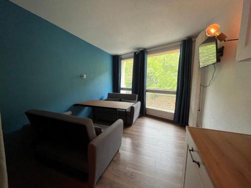 un salon avec un canapé, une table et une fenêtre dans l'établissement Studio au pied des pistes avec balcon et parking à Villard-de-Lans - FR-1-515-145, à Villard-de-Lans