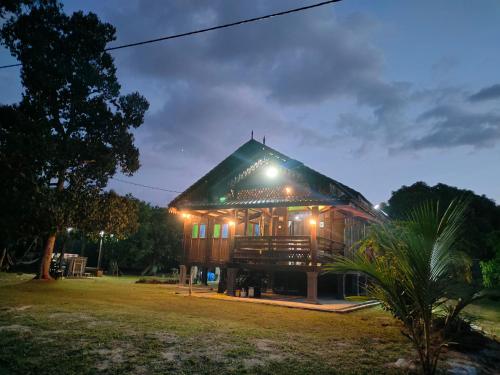 a house with a lit up roof at night at Homestay Kampung Den in Kampong Jimah
