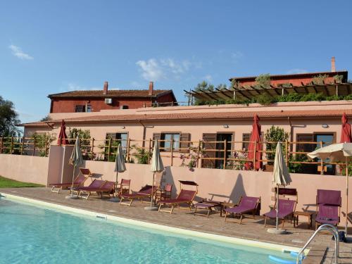 a hotel with chairs and umbrellas next to a swimming pool at Farmhouse near Montalto di Castro beaches in Montalto di Castro