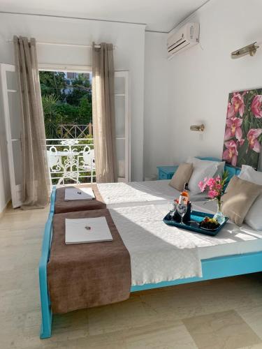 a bedroom with a bed with a tray of food on it at Stratos Hotel in Pythagoreio
