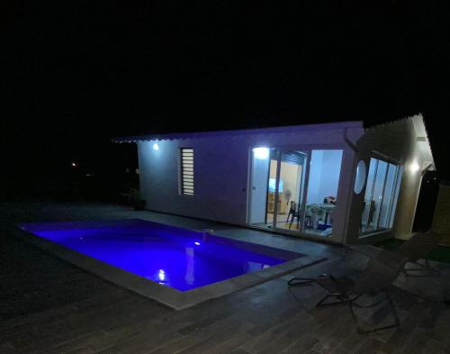 a swimming pool at night in front of a house at Villa Catalina in Le Moule