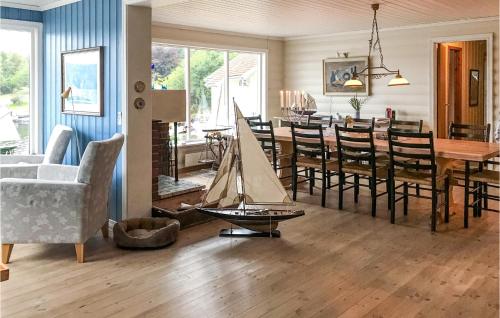 ein Esszimmer mit einem Tisch und einem Spielzeugboot auf dem Boden in der Unterkunft Gorgeous Home In Farsund With Kitchen in Farsund
