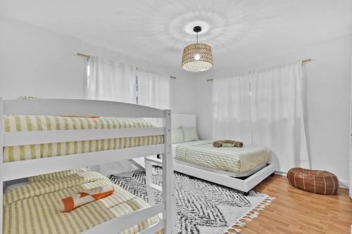 - une chambre blanche avec 2 lits superposés et un tapis dans l'établissement Private Lakefront Home in Miami/Pembroke, à Pembroke Pines