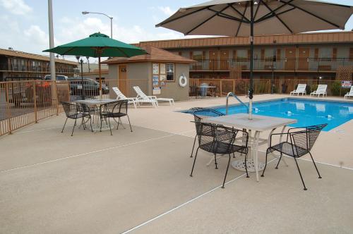 a patio with tables and chairs next to a pool at Executive Inn and Suites Springdale in Springdale