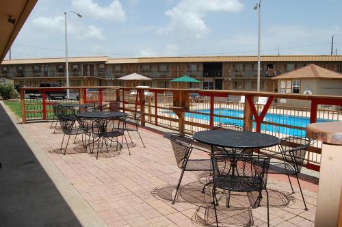 a patio with tables and chairs next to a pool at Executive Inn and Suites Springdale in Springdale