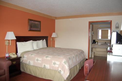 a hotel room with a bed and a television at Executive Inn and Suites Springdale in Springdale