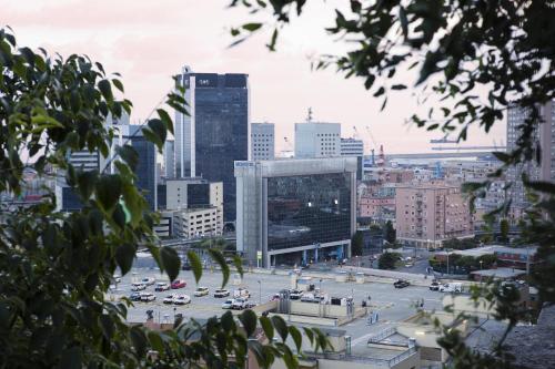 a view of a city with cars in a parking lot at Novotel Genova City in Genova