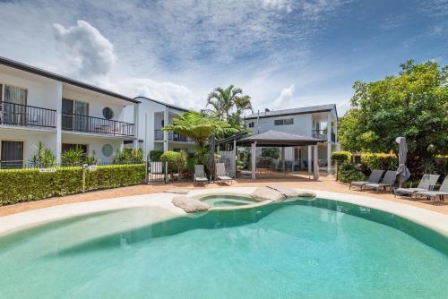 a large swimming pool in front of a house at Anchor Motel Noosa in Noosaville