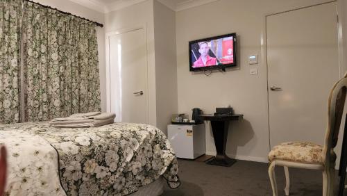 sypialnia z łóżkiem i telewizorem na ścianie w obiekcie Gowrie Agapanthus w mieście Singleton