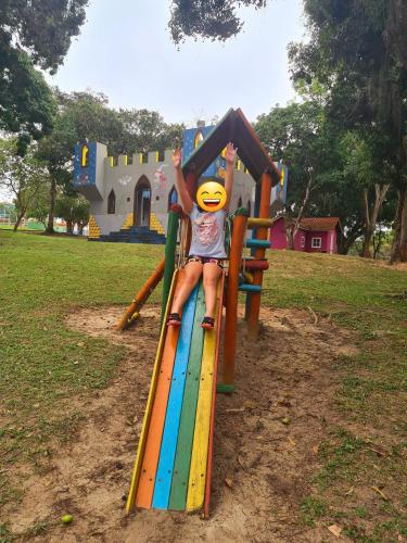 a young child is playing on a slide at a playground at Casa em Condomínio com Piscina Privativa in Araruama