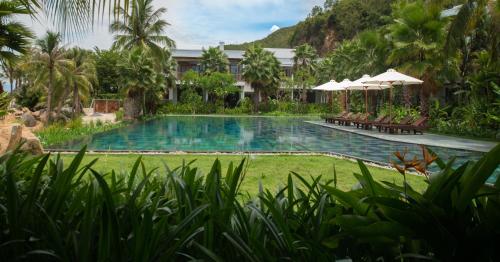 - une piscine dans un complexe avec des chaises et des parasols dans l'établissement Alibu Resort Nha Trang, à Nha Trang