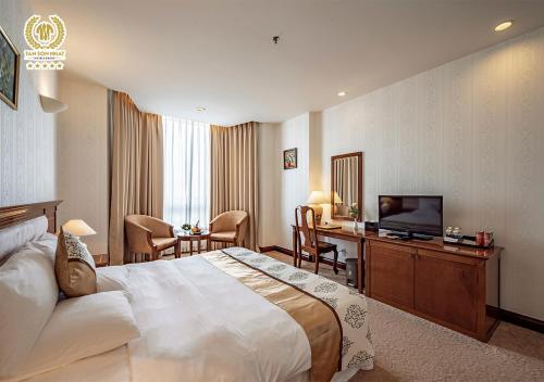 a hotel room with a large bed and a television at Tan Son Nhat Saigon Hotel in Ho Chi Minh City