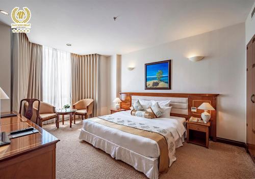 a hotel room with a bed and a desk at Tan Son Nhat Saigon Hotel in Ho Chi Minh City
