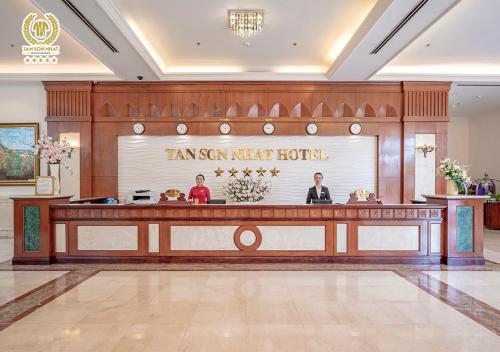 a lobby of a hotel with two people standing at a counter at Tan Son Nhat Saigon Hotel in Ho Chi Minh City