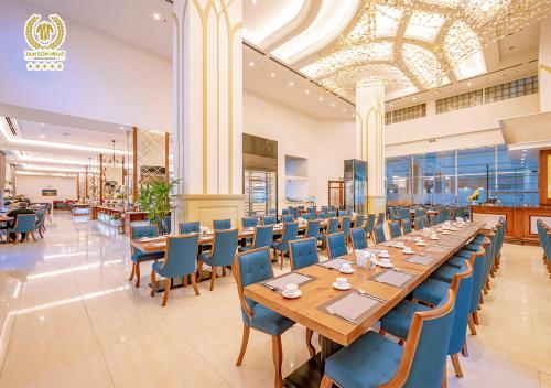 a dining room with a long table and blue chairs at Tan Son Nhat Saigon Hotel in Ho Chi Minh City