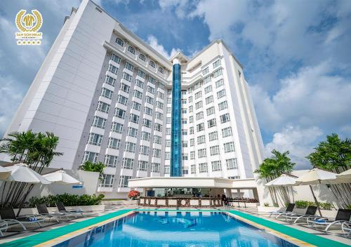 un hôtel avec une piscine en face d'un bâtiment dans l'établissement Tan Son Nhat Saigon Hotel, à Hô-Chi-Minh-Ville