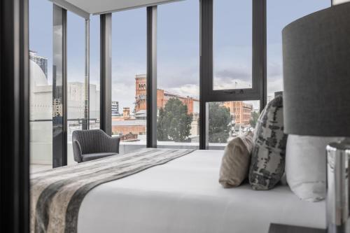 um quarto com uma cama e uma grande janela em FV by Peppers em Brisbane