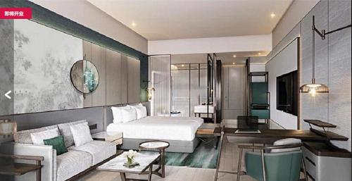 um quarto de hotel com uma cama e um sofá em HUALUXE Leshan, an IHG Hotel em Leshan