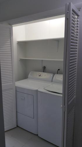 a small white kitchen with a washer and dryer at Downtown Hollywood Boutique Hotel in Hollywood