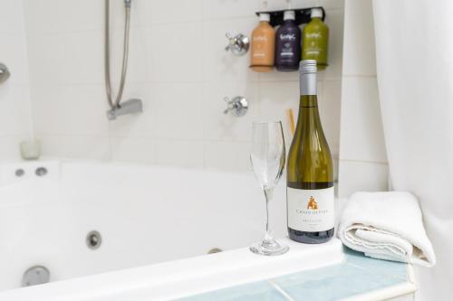 a bottle of wine and a glass on a counter in a bathroom at Holiday Inn Parramatta by IHG in Sydney