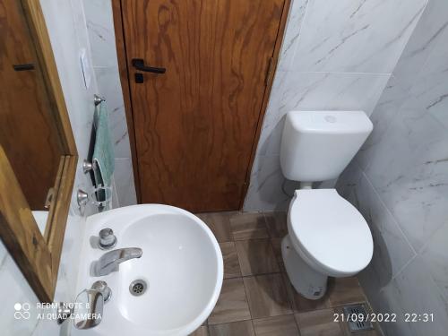 uma casa de banho com um WC branco e um lavatório. em Departamentos Rosales em Valeria del Mar