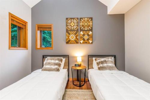 2 Betten in einem Zimmer mit einem Tisch und Fenstern in der Unterkunft Relaxing 2Bedroom Townhome w/Playroom & Great View in Galena