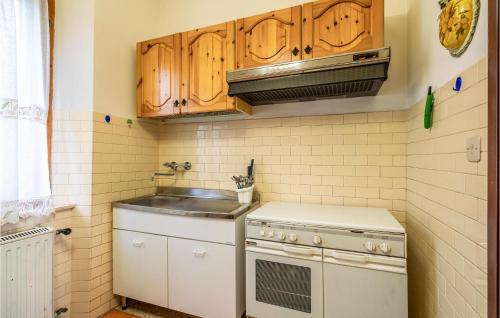 a kitchen with wooden cabinets and a stove top oven at Amazing Home In Slorenzo Al Lfiastra in Fiume