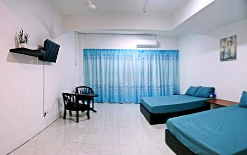 um quarto com duas camas, um sofá e uma mesa em “Alan Homestay” Pangkor Lot 10 em Kampong Sungai Udang