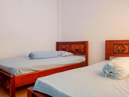 2 camas individuales en una habitación con 3 camas individuales que establece que en Homestay Awal Fajar Syariah Bulukumba, en Bulukumba