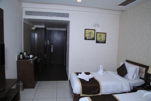 a hotel room with two beds and a bathroom at WEST FORT HOTEL in Bengaluru