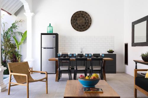 a kitchen with a table with chairs and a refrigerator at Villa Toru - Stylish luxury in Legian, tranquil location, walk to beach in Legian