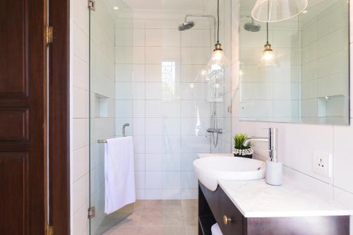 a white bathroom with a sink and a mirror at Villa Toru - Stylish luxury in Legian, tranquil location, walk to beach in Legian