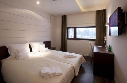 pokój hotelowy z łóżkiem i ręcznikami w obiekcie Villa & Spa w mieście Łomianki